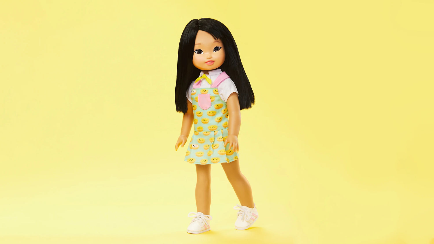 The Jilly doll  wearing an apron-inspired dress, short-sleeved shirt, bowtie and plastic sneakers